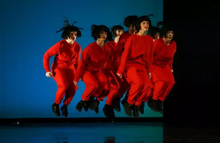 People in red outfits jumping at the same time